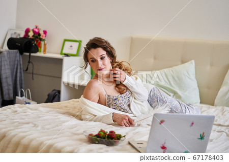 Beautiful girl at home on the bed at the computer Beautiful girl at home on the bed at the computer 67178403