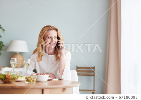 Elegant Mature Woman Speaking by Phone and Smiling Elegant Mature Woman Speaking by Phone and Smiling 67180093