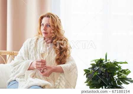 Beautiful Mature Woman Holding Champagne Glass at Home Beautiful Mature Woman Holding Champagne Glass at Home 67180154