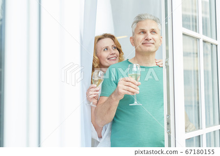 Mature Couple Looking Out of Window in Hotel Mature Couple Looking Out of Window in Hotel 67180155