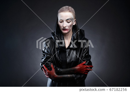 Picture of woman in black leather raincoat with red hands 67182256