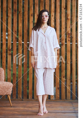 Woman in pajamas over wooden background on terrace. Good morning concept. 67183234