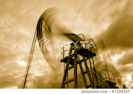 Petroleum concept. Oil pump rig. Oil and gas production. Oilfield site. Pump Jack are running. Drilling derricks for fossil fuels output and crude oil production. Global crisis. War on oil prices. 67184567
