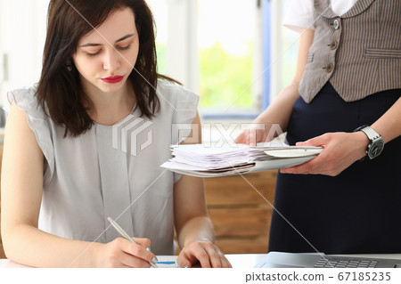 Serious manager signing a document in the office 67185235