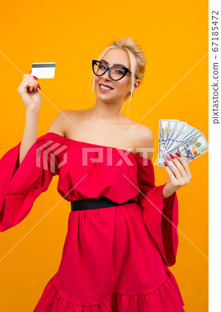 blond sexy girl in a red dress with bare shoulders holds a bunch of loan money and a credit card credit mockup on an isolated studio background blond sexy girl in a red dress with bare shoulders holds a bunch of loan money and a credit card credit mockup on an isolated studio background 67185472