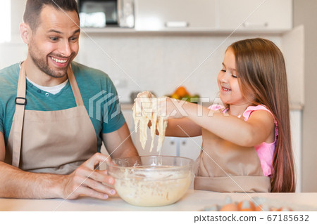 Father And Daughter Baking Together Playing Kneading Dough Sitting Indoors Father And Daughter Baking Together Playing Kneading Dough Sitting Indoors 67185632