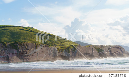 Beautiful ecological land of Basque Autonomous Community / country. Charming Zumaia Itzurun beach. Natural green summer rural background of trees, grass and soft clouds on sky. 67185738