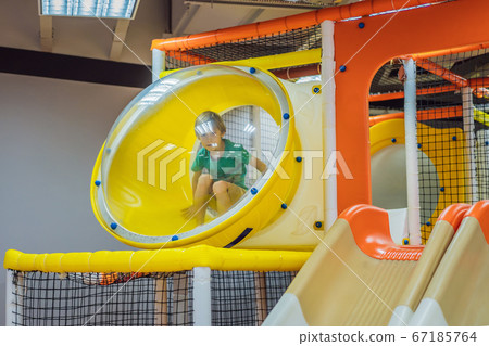 The boy has fun in an indoor playground The boy has fun in an indoor playground 67185764