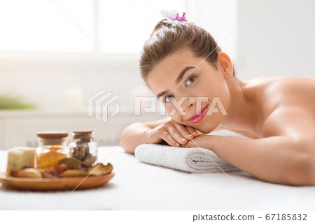 Young pretty woman waiting for massage session and aroma plate Young pretty woman waiting for massage session and aroma plate 67185832