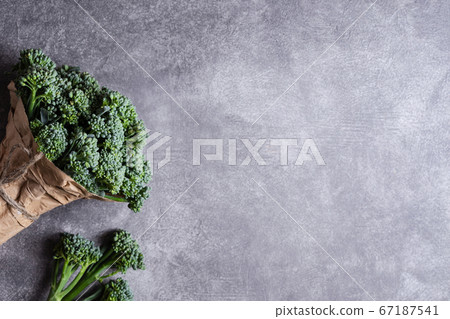 Bunch of broccolini on grey stone background. 67187541