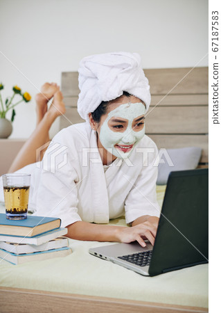 Woman doing homework in bed 67187583