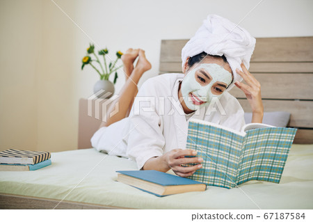 Young woman reading in bed Young woman reading in bed 67187584