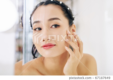 Young woman looking at mirror 67187649