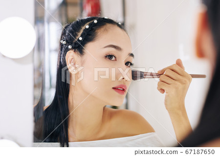 WOman powdering face WOman powdering face 67187650