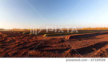 Rows of cutted peat in Northwestern Germany Rows of cutted peat in Northwestern Germany 67189589