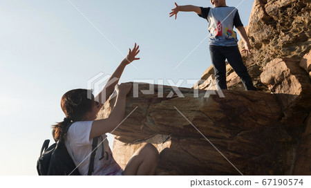 Mom ask helping son hand at hill peak Mom ask helping son hand at hill peak 67190574