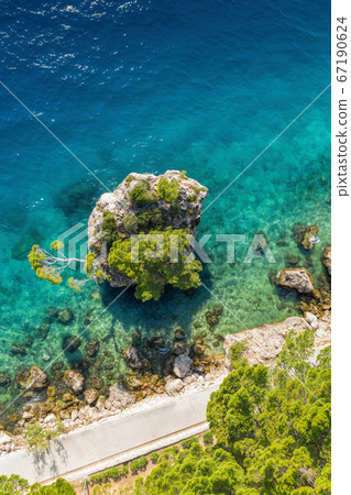 Famous Punta Rata beach with little island in Brela, Dalmatia, Croatia Famous Punta Rata beach with little island in Brela, Dalmatia, Croatia 67190624