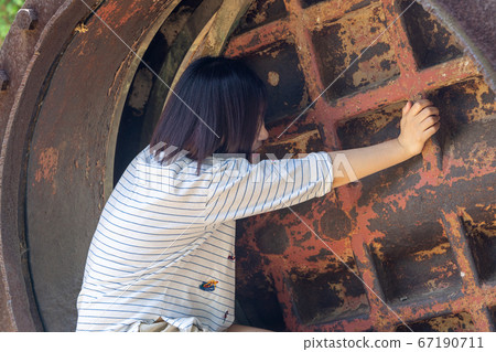 一個女人試圖用手打開一個大的舊門 67190711