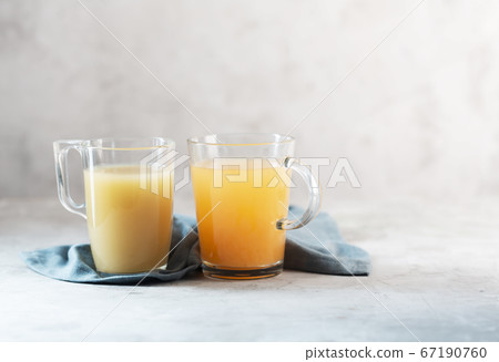 Glasses with Homemade Beef Bone Broth on a gray Glasses with Homemade Beef Bone Broth on a gray 67190760