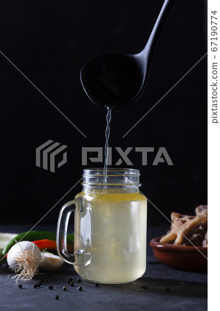 Pouring Homemade Beef Bone Broth in Glass Storage Pouring Homemade Beef Bone Broth in Glass Storage 67190774