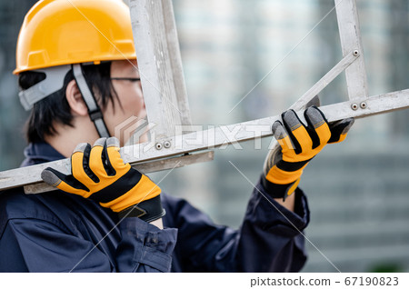 Maintenance worker man carrying aluminium ladder Maintenance worker man carrying aluminium ladder 67190823
