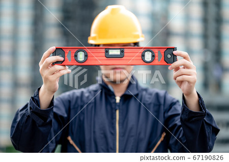 Worker man holding red aluminium spirit level tool Worker man holding red aluminium spirit level tool 67190826