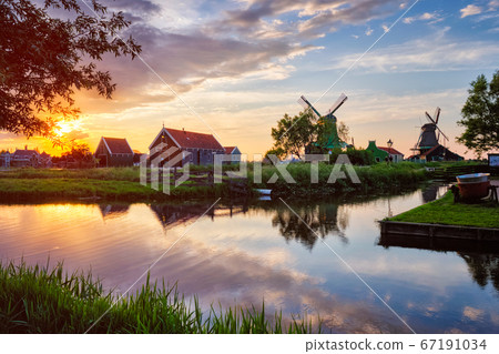 Windmills at Zaanse Schans in Holland on sunset. Zaandam, Nether Windmills at Zaanse Schans in Holland on sunset. Zaandam, Nether 67191034