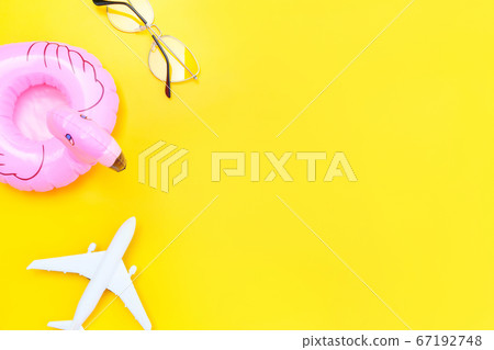 Summer beach composition. Minimal simple flat lay with plane sunglasses and Inflatable flamingo isolated on yellow background. Vacation travel adventure trip concept. Top view copy space. Summer beach composition. Minimal simple flat lay with plane sunglasses and Inflatable flamingo isolated on yellow background. Vacation travel adventure trip concept. Top view copy space. 67192748