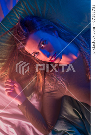 Portrait of a young woman on a bed from above Portrait of a young woman on a bed from above 67192782