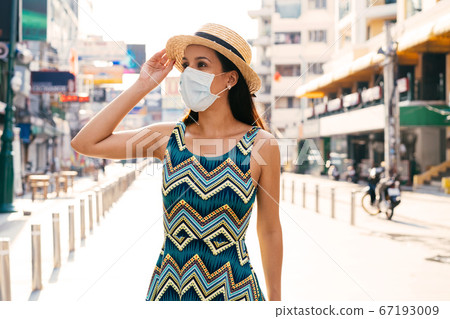 Young Mexican woman wearing face mask in city Young Mexican woman wearing face mask in city 67193009