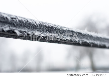 Hoarfrost on the black handrail. Hoarfrost on the black handrail. 67194436