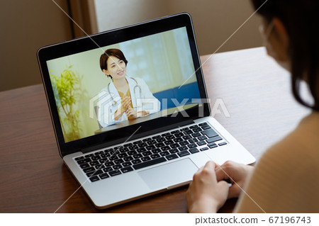 Woman receiving online medical treatment Woman receiving online medical treatment 67196743