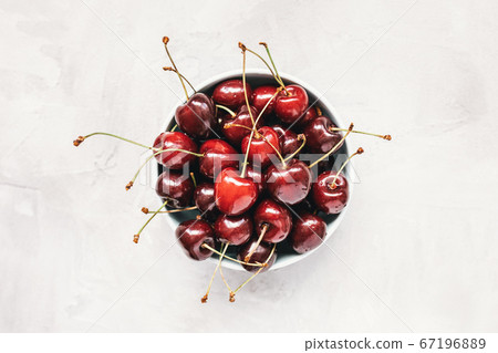 Fresh ripe cherries in a bowl on a gray background Fresh ripe cherries in a bowl on a gray background 67196889