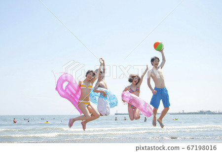 Men and women playing in the sea 67198016