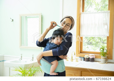 Mom holding a baby toothpaste Mom holding a baby toothpaste 67198624