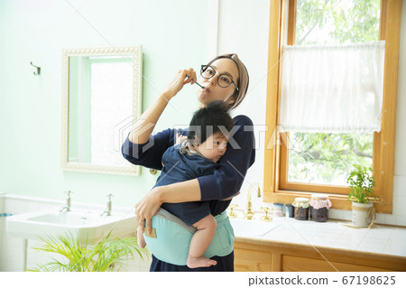 Mom holding a baby toothpaste Mom holding a baby toothpaste 67198625