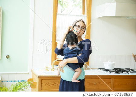 Mom holding a baby toothpaste Mom holding a baby toothpaste 67198627