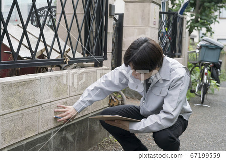 Businessman investigating the wall of a dilapidated house 67199559