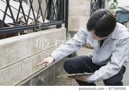 Businessman investigating the wall of a dilapidated house 67199560