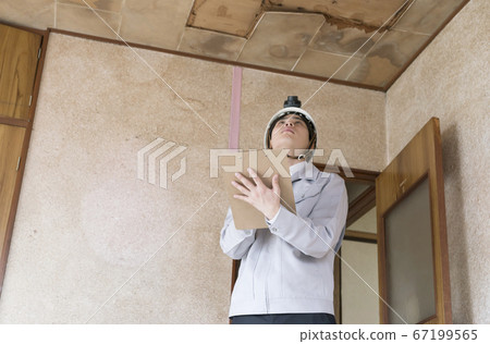 商人在房屋翻新前調查漏水的天花板 67199565