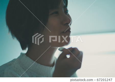 Alassa woman eating with a spoon 67201247