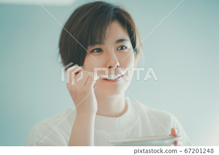 Alassa woman eating with a spoon 67201248