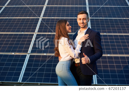 Beautiful couple by a solar panel 67203137