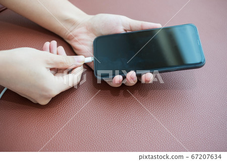 Woman hands charging battery in mobile smart phone Woman hands charging battery in mobile smart phone 67207634