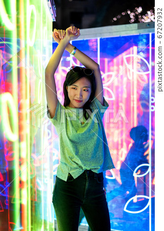 Asian woman portrait lit up by neon lights at Asian woman portrait lit up by neon lights at 67207932