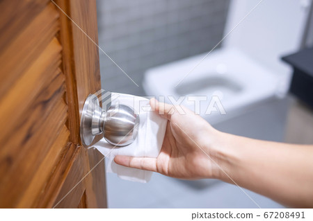 Woman hand cleaning toilet doorknob by wet wipe Woman hand cleaning toilet doorknob by wet wipe 67208491