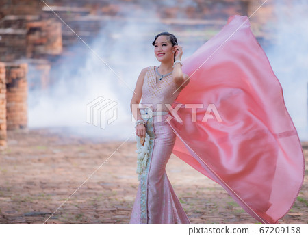 Woman wearing typical thai dress with thai style, Beauty fantasy Thai dress traditional costume on brick in old temple Woman wearing typical thai dress with thai style, Beauty fantasy Thai dress traditional costume on brick in old temple 67209158