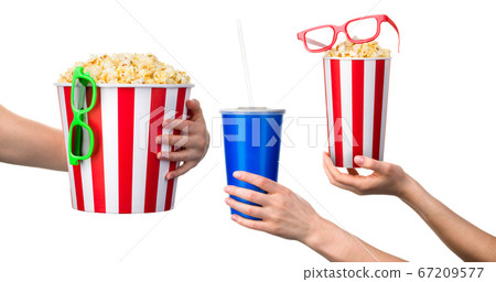 Woman hand holding striped bucket with popcorn isolated on white background Woman hand holding striped bucket with popcorn isolated on white background 67209577