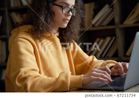 Serious hispanic teen girl college student using laptop study work online. 67211734