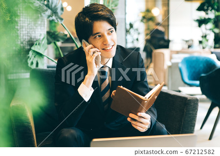 Business man, telephone call, looking at notebook Business man, telephone call, looking at notebook 67212582